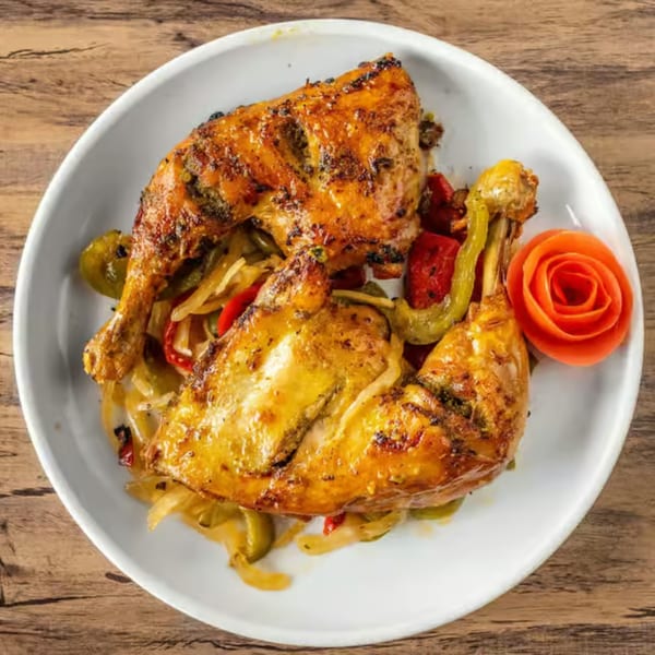 Grilled chicken quarters with sautéed peppers and onions, garnished with a carrot rose.